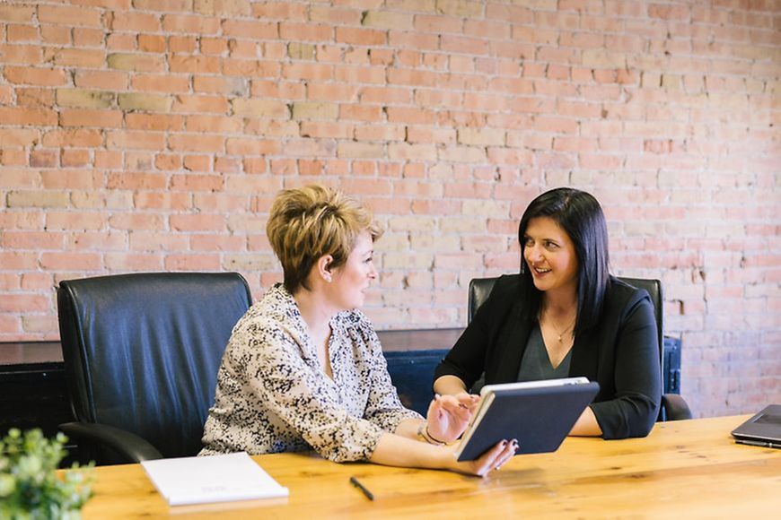 Zwei Frauen unterhalten sich am Tisch