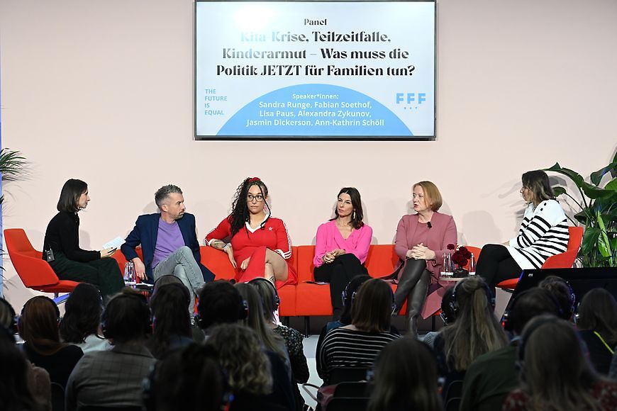 Lisa Paus sitzt mit fünf Personen auf dem Podium